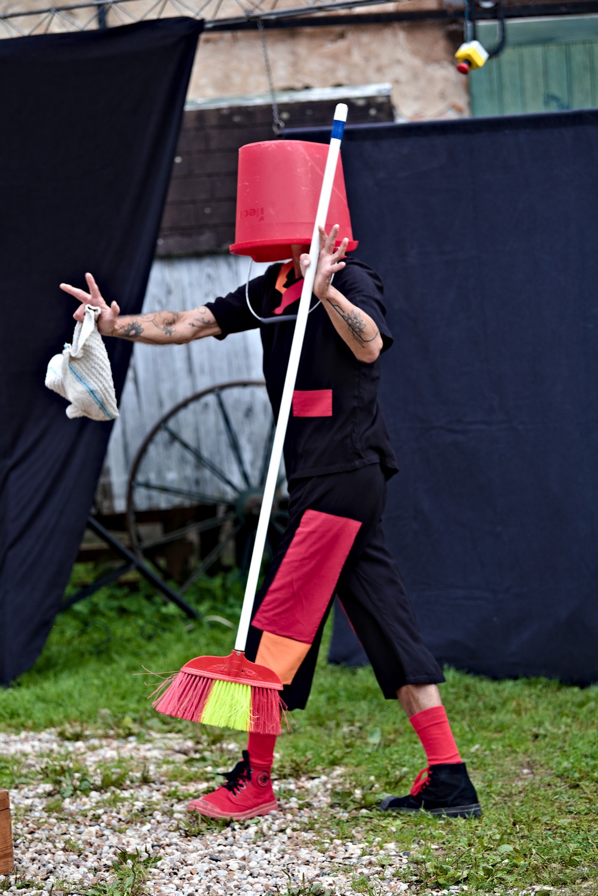 Tommy sur scène avec un seau sur la tête mime la confusion dans le spectacle de rue mutation